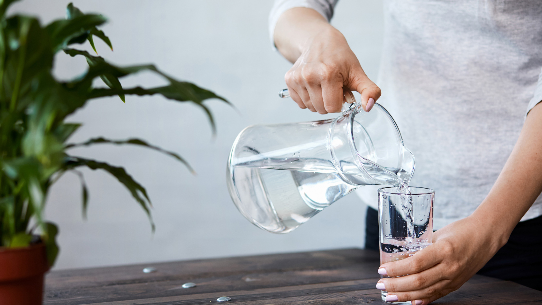 Woman pouring a glass of water. Image: canva