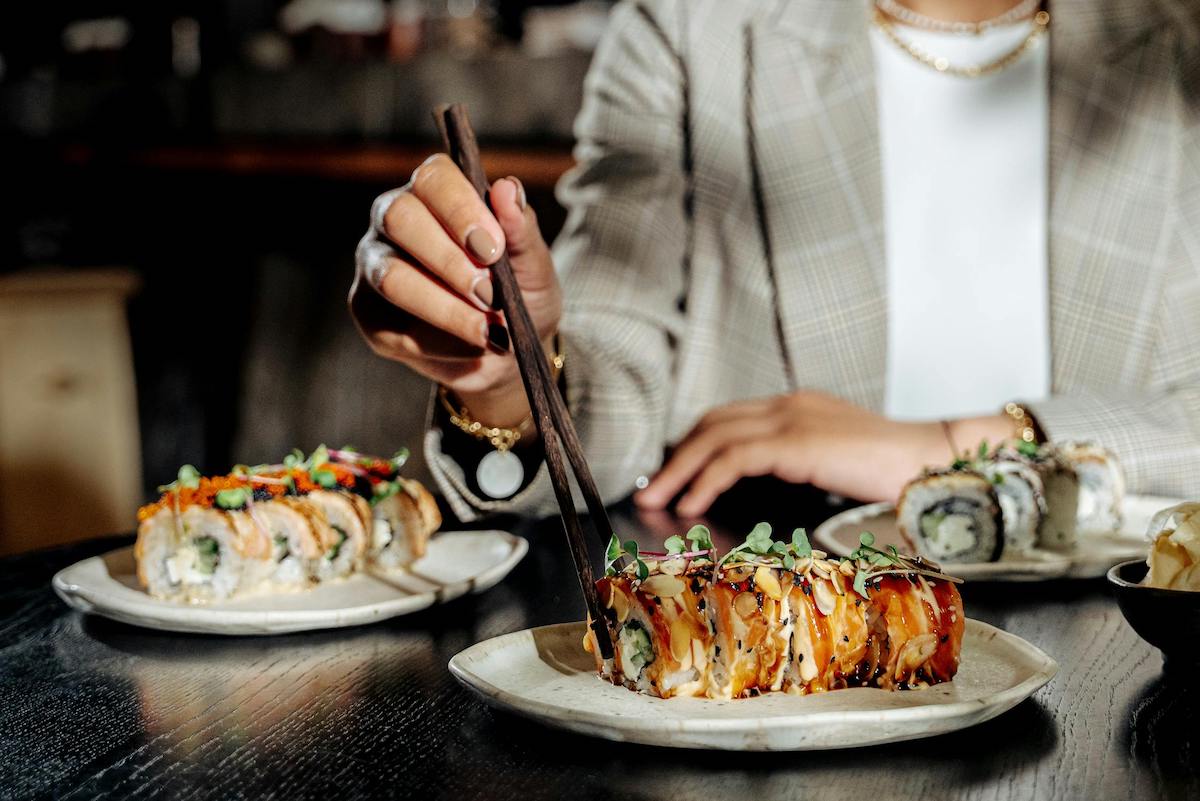 Woman eating sushi with chopsticks. Image: Pexels - Ivan Samkov