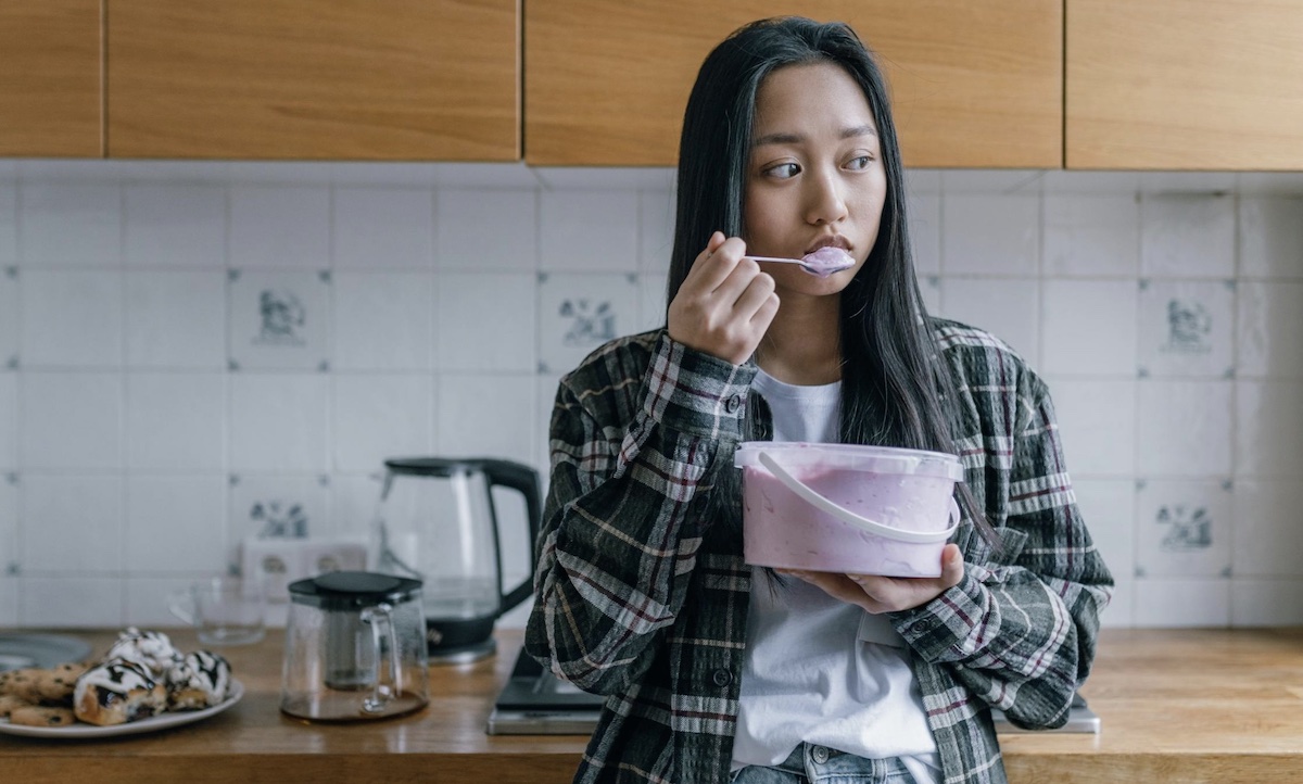 Girl eating emotionally a pint of ice cream