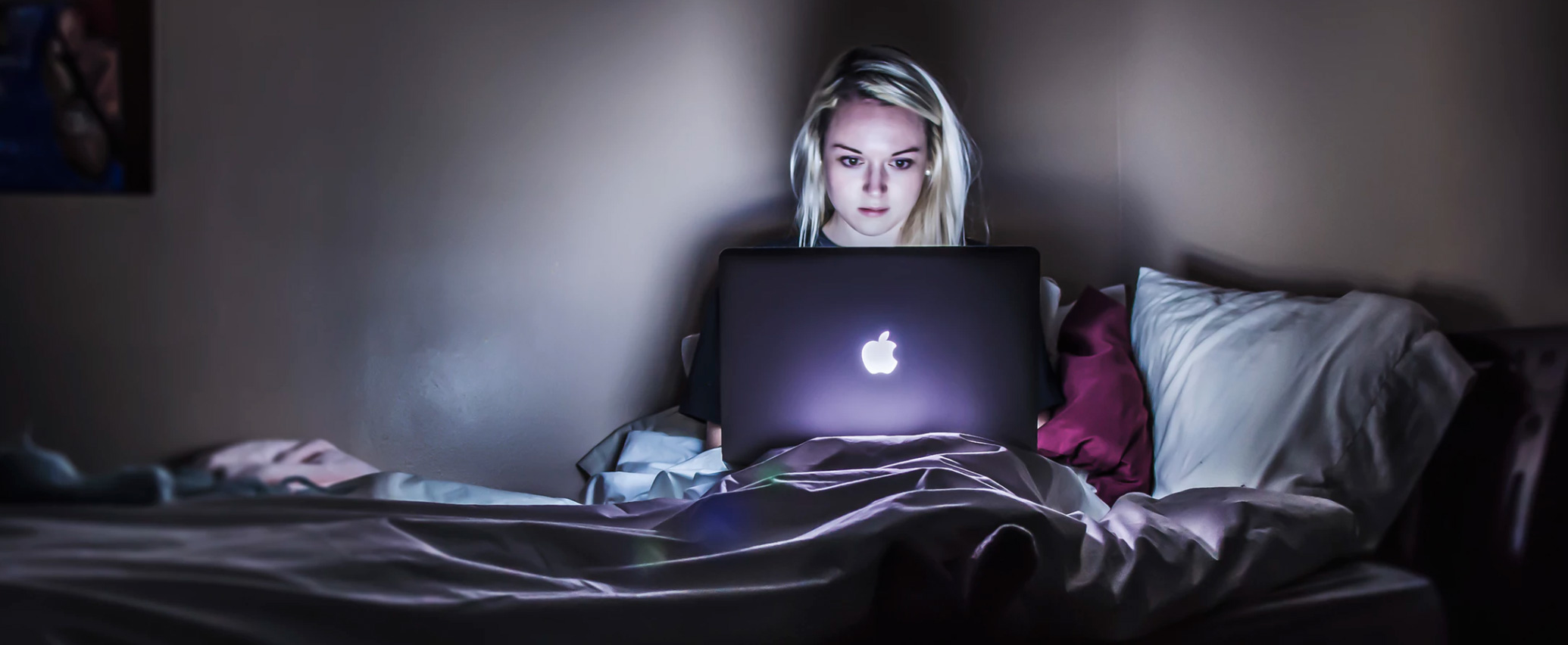 Ragazza con laptop a letto