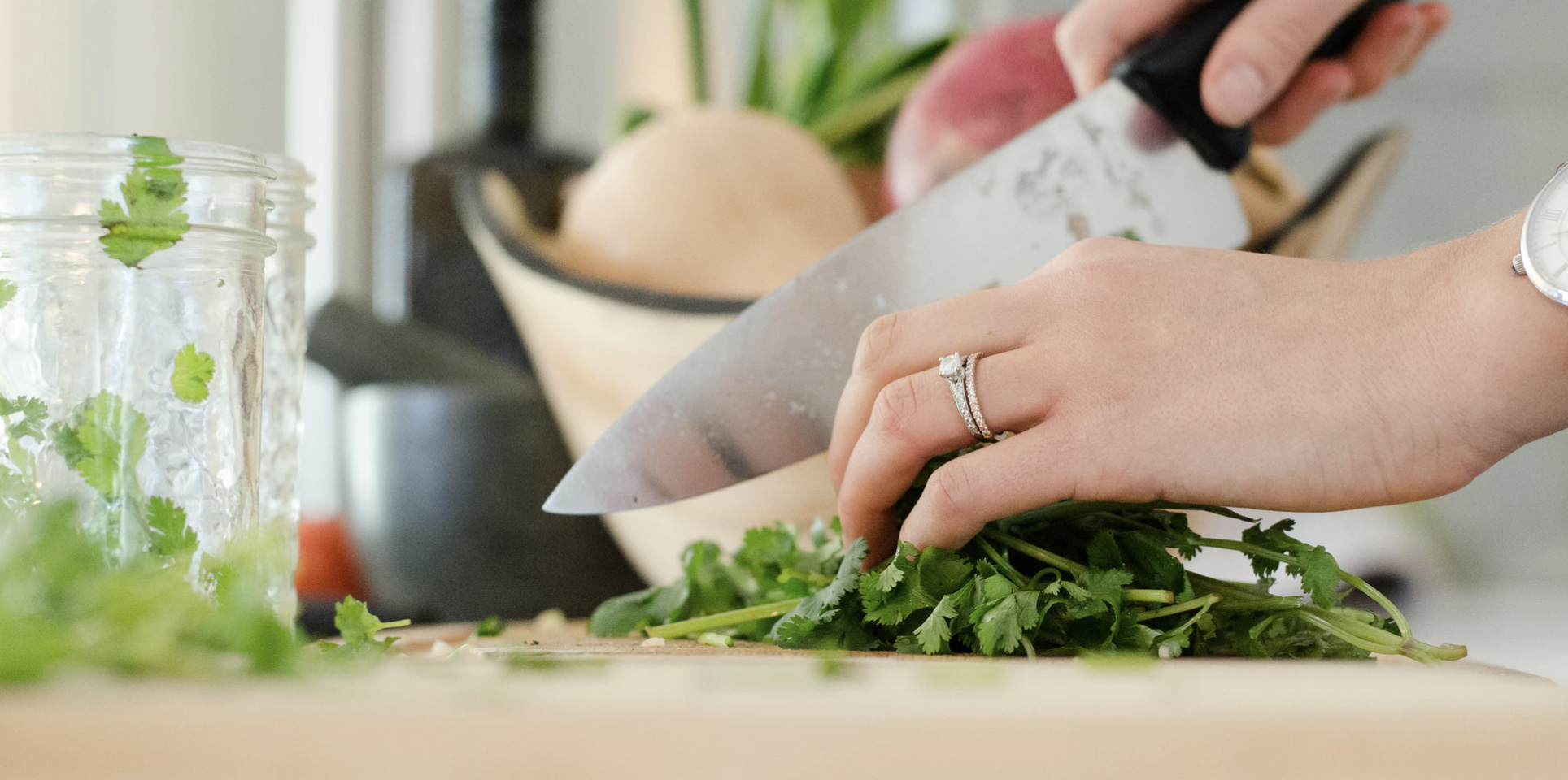 Woman sliceing parsley with a knife in the kitchen