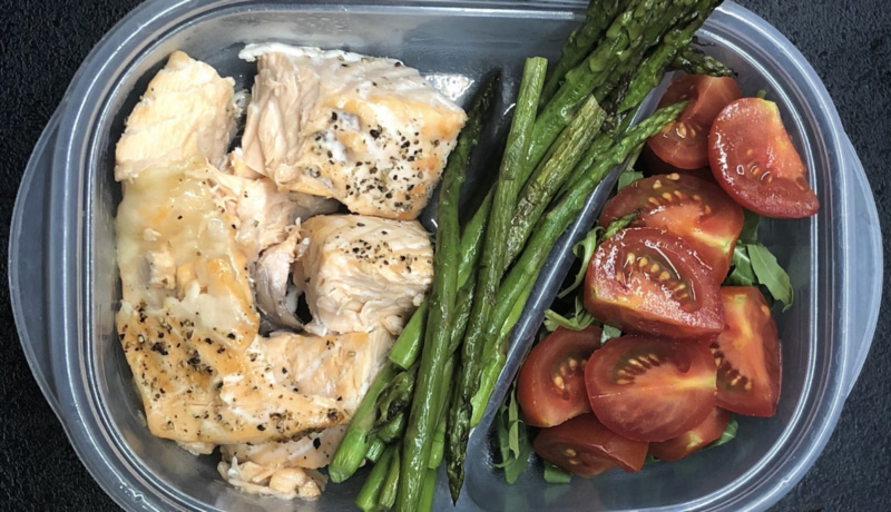 Asparagus, fish, tomato in tupperware