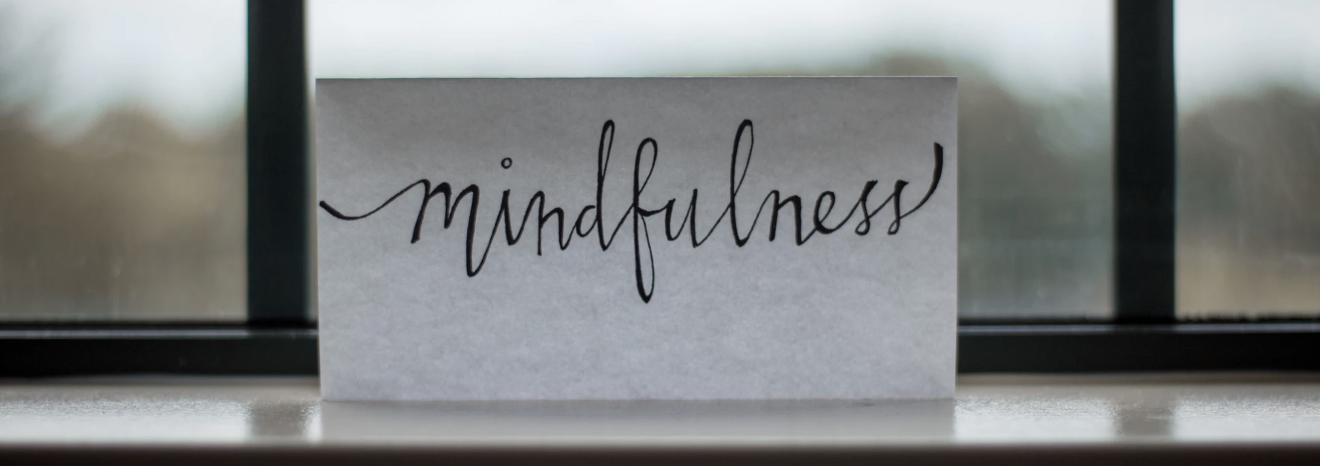 A paper in the window with a mindfulness caption on it