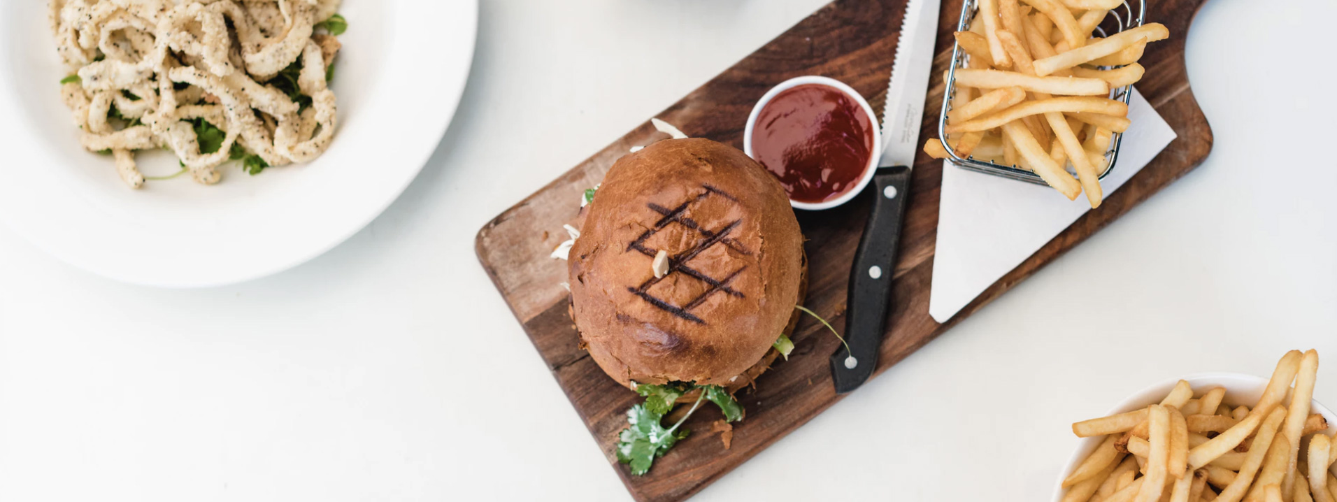 Hamburger and fried potatoes on a table