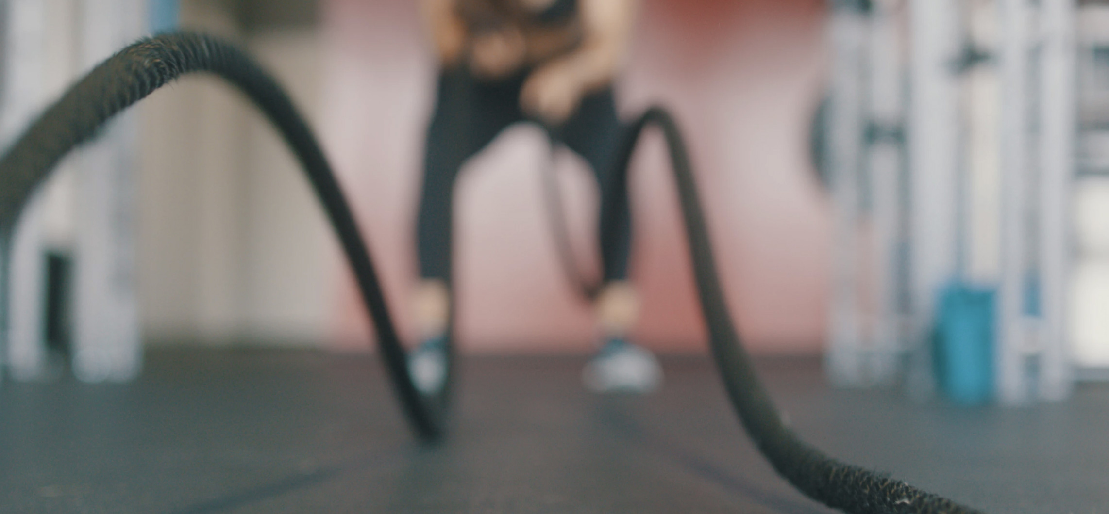 Woman is doing workout in a fitness room with rope