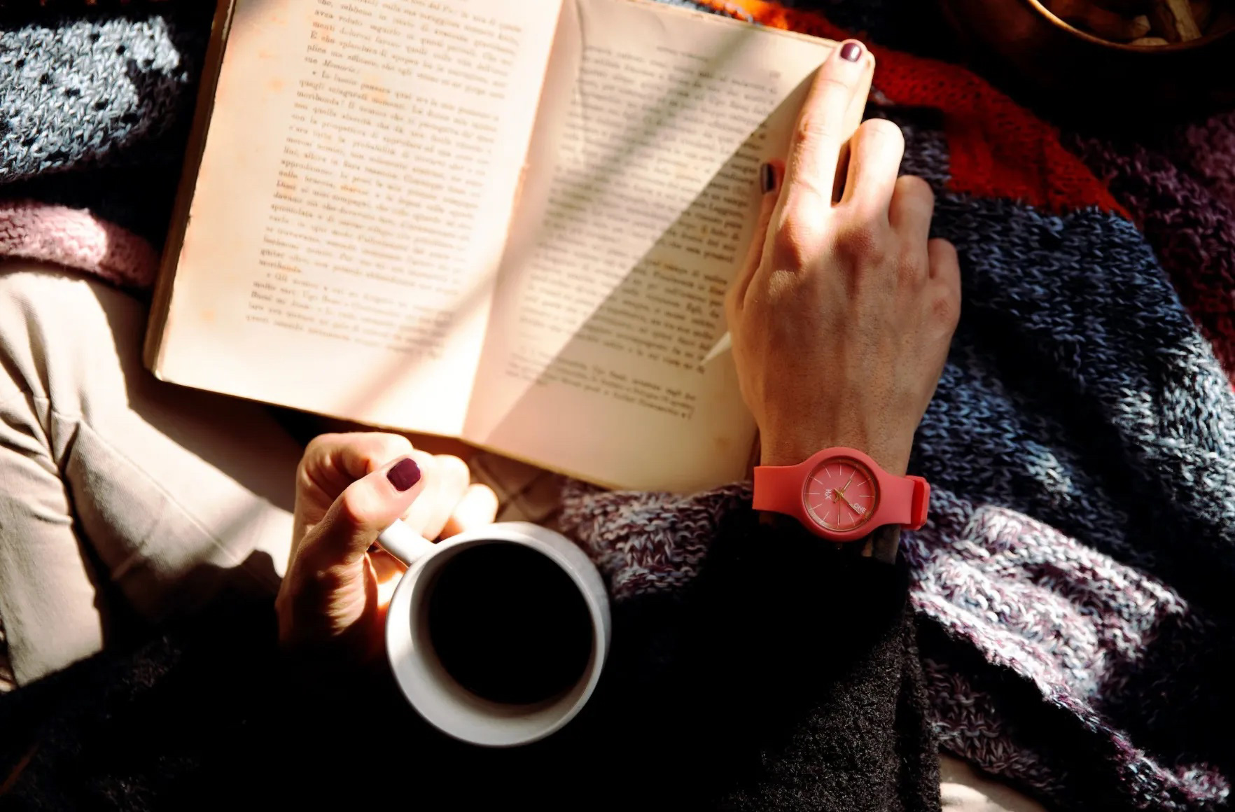 Reading a book with a coffee. Image: Pexels - Vincenzo Malagoli
