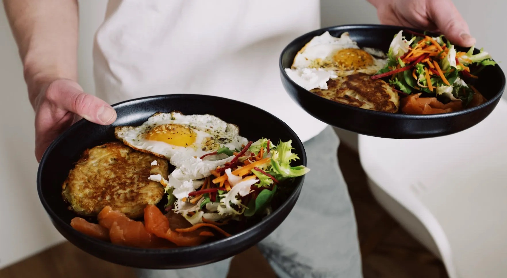 Man holding two plates full of food.