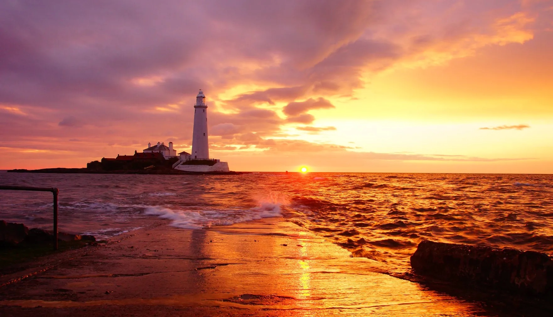 Lighthouse on the sea at sunset.