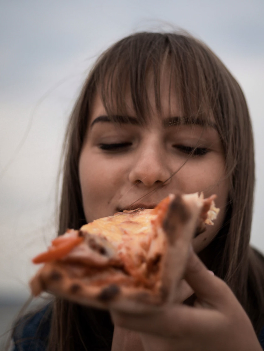 Girl eating a slice of pizza 