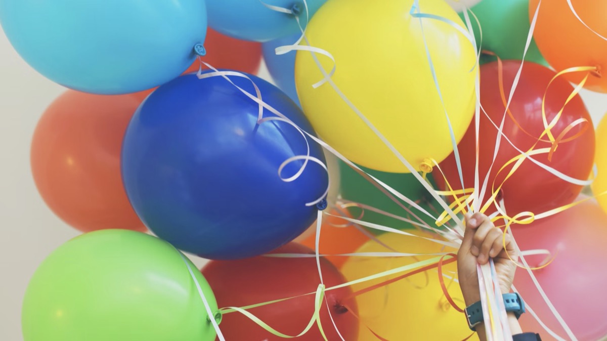 Person holding balloons in the air. 