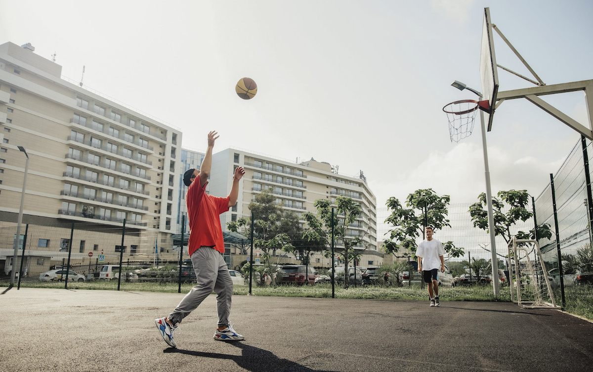 Playing basketball on an outdoor court. 