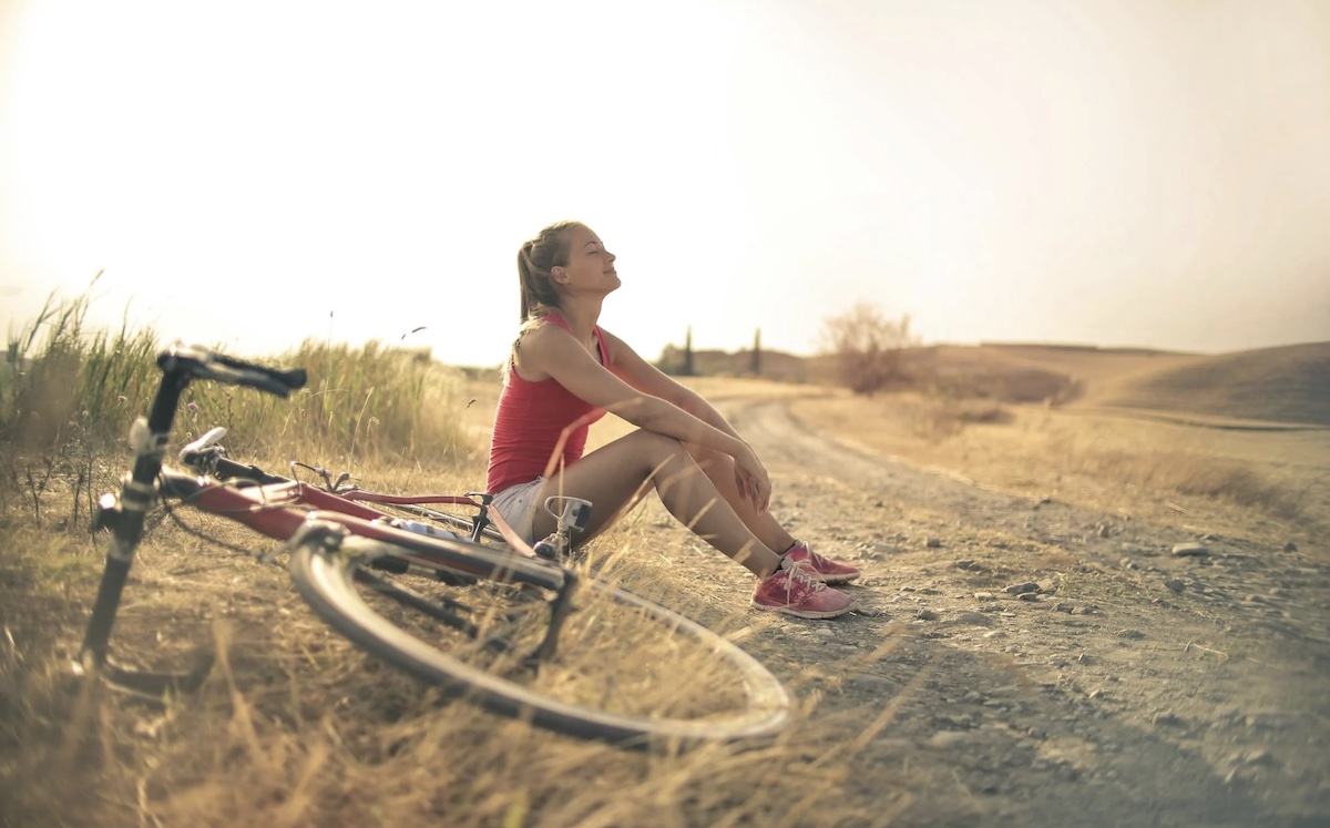 Woman riding bike and taking a break. Image: Pexels - Andrea Piacquadio