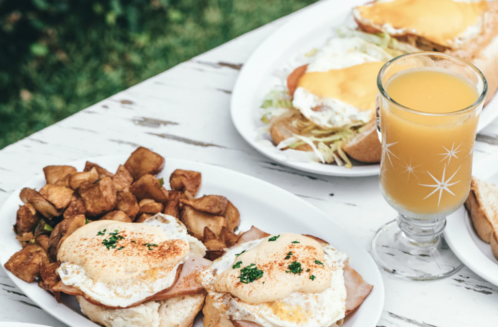 An egg brunch with hash browns and orange juice for more individuals 