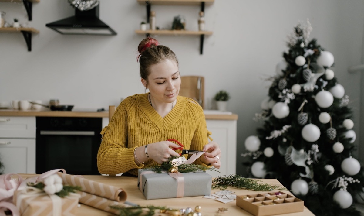 Woman wrapping presents during holiday season. Image: Pexels - Julia Volk 