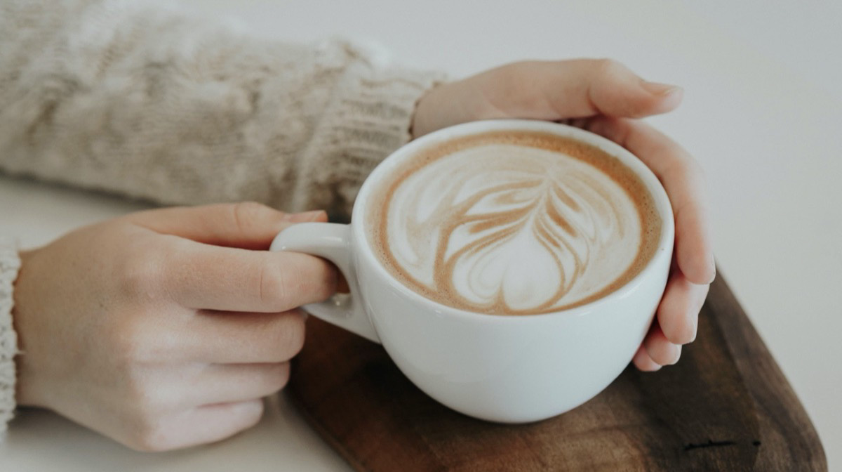 Woman holding a cup of coffee. Unsplash - Christiana Rivers