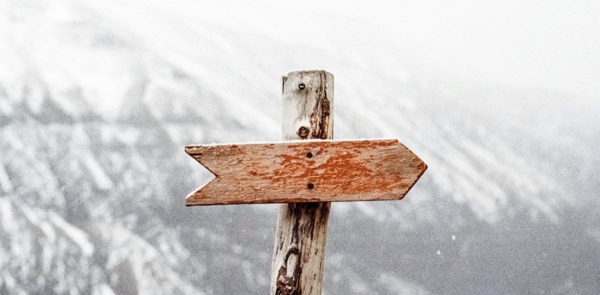 Winter weather with a wooden arrow pointing in a direction. Pexels - Jens Johnsson