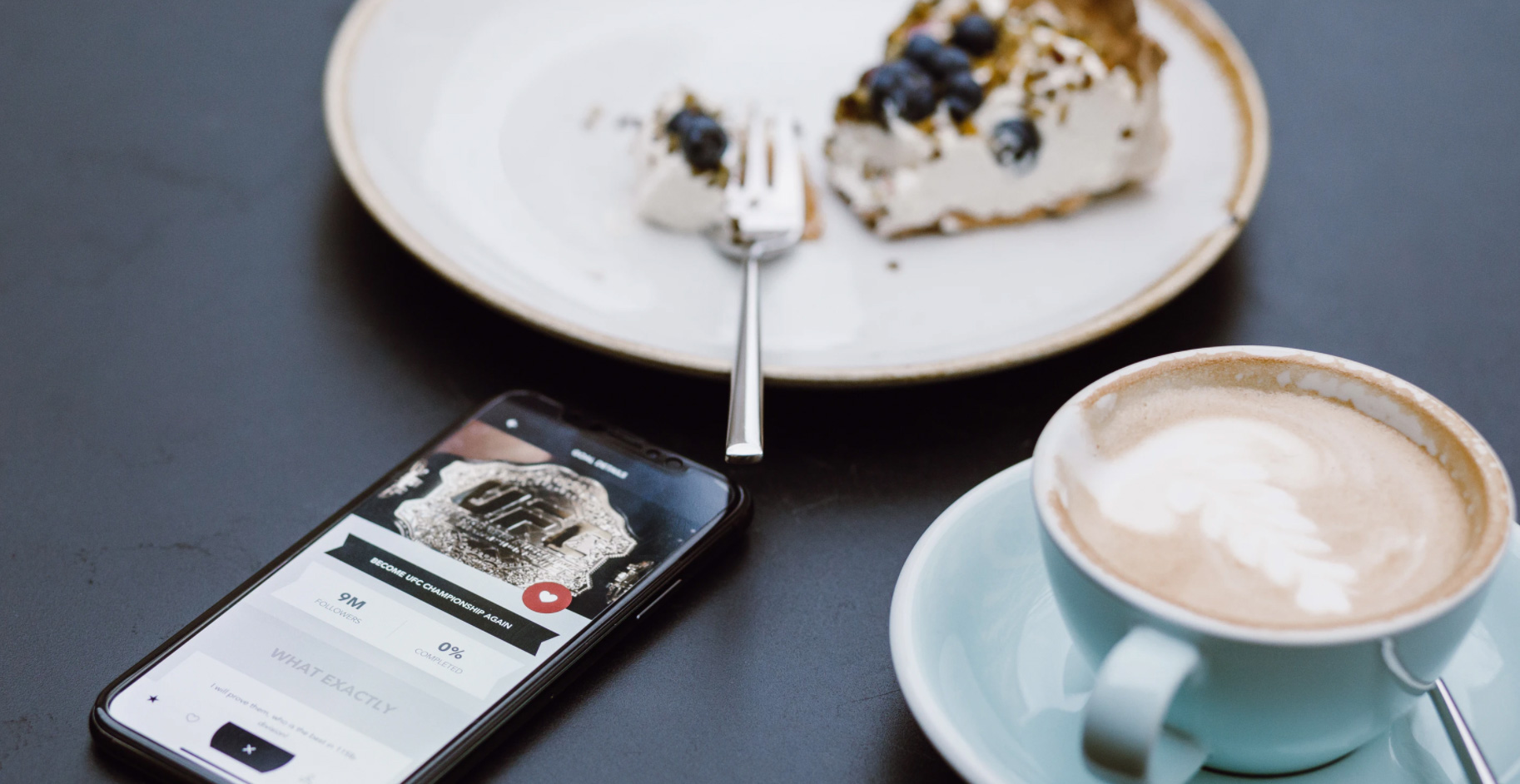 Plate of food and coffee with phone