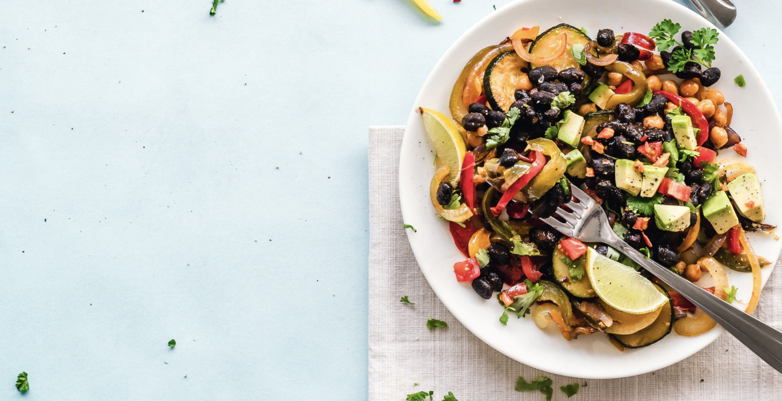 Bowl of food with avocado lemons and many other veggies