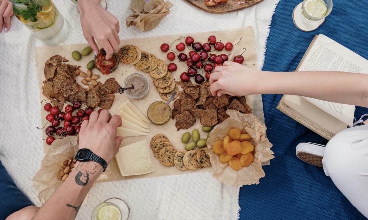 Friends eating together off of a cheese plate 