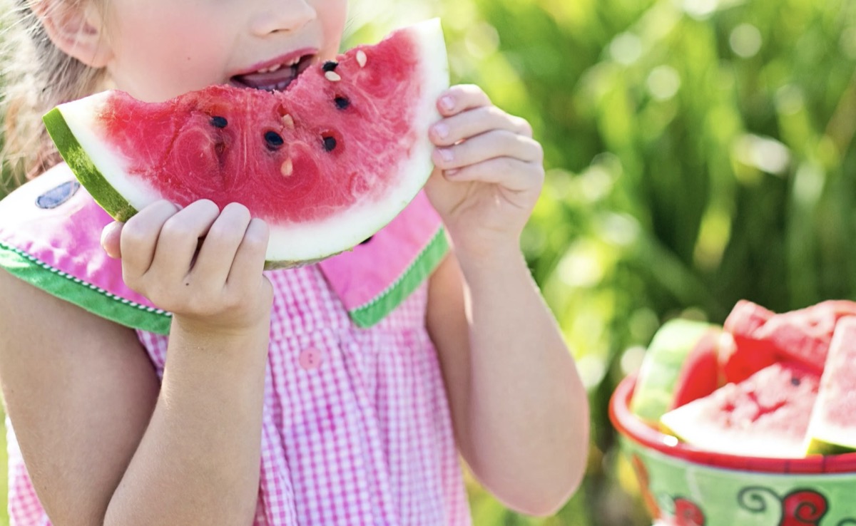 Child eating watermelon in summer