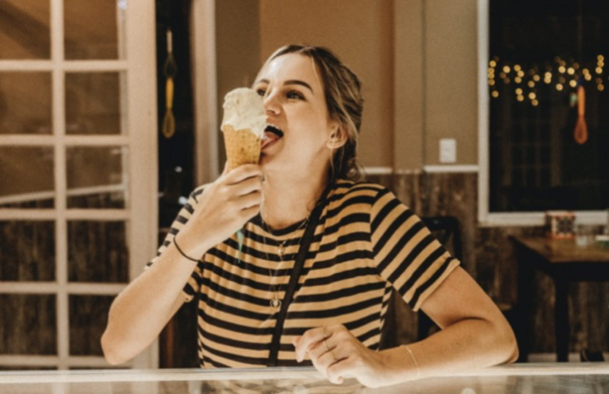 Girl enjoying an ice cream from a cone.