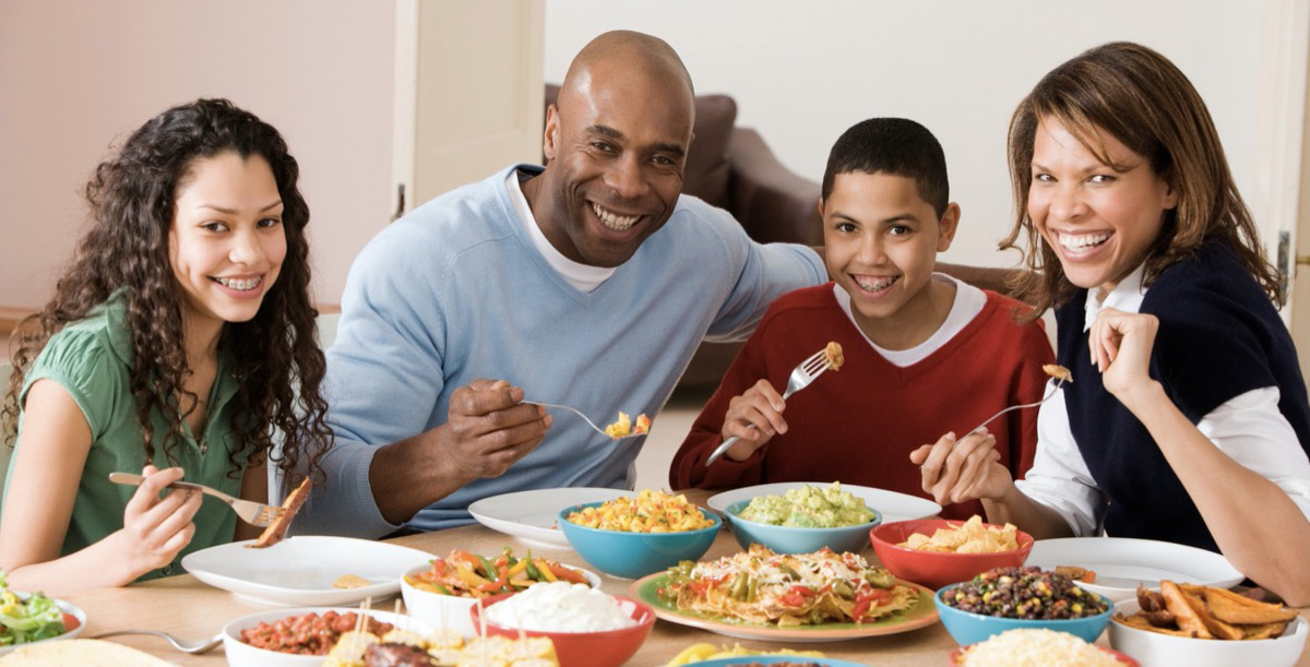 Family dinner with parents and two children enjoying dinner. 