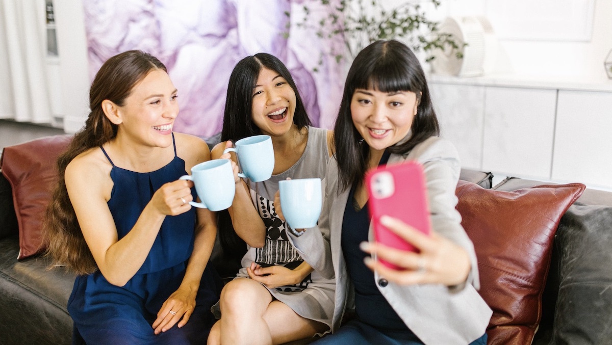 Three female friends spending time together taking selfie.