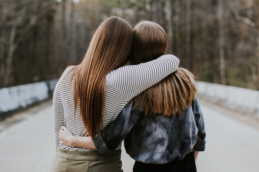 Two friends hugging each other. 