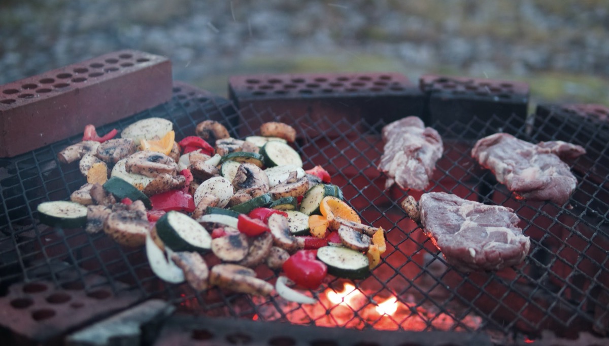 Grilling vegetables and meat on a grill 