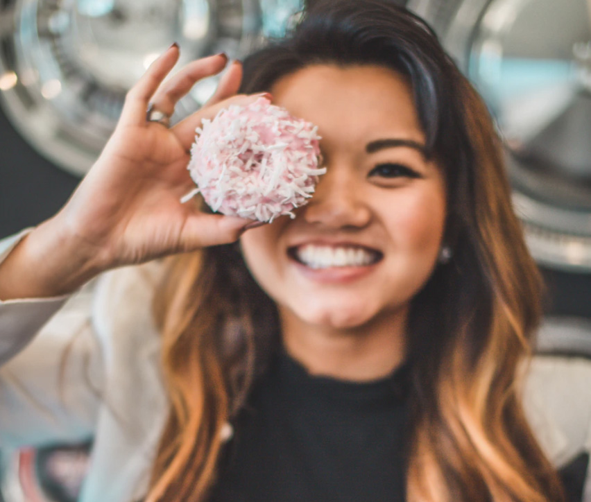 Woman smiling with donut in hand