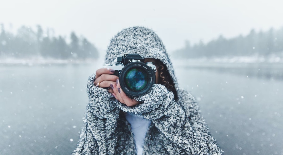 Woman taking a picture in the snow 