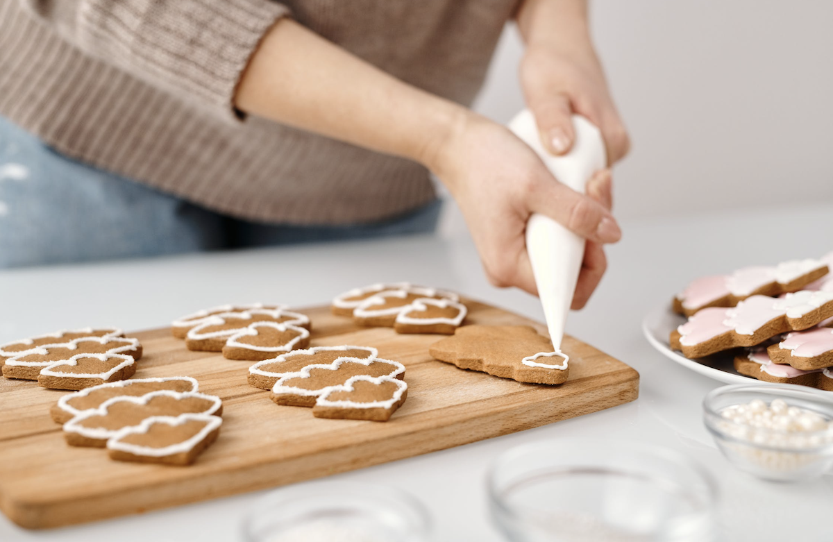 Woman decorating gingerbread cookies 