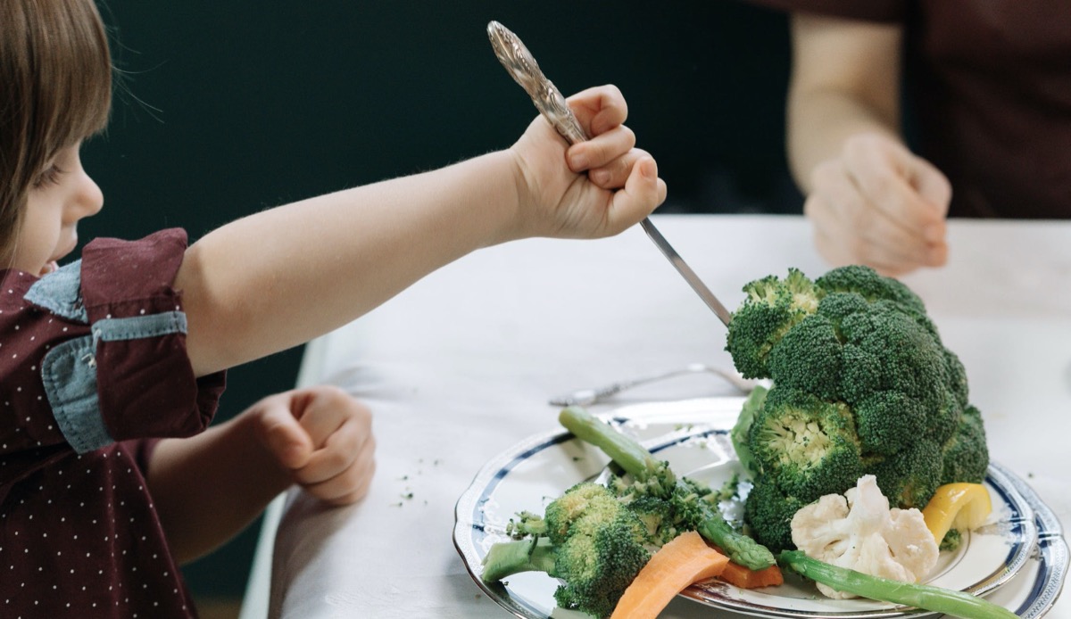 Child eating plate of vegetables