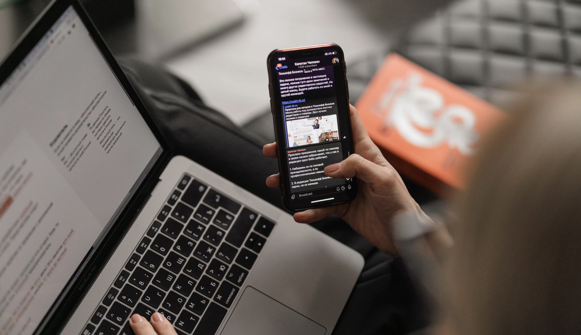 Woman looking at phone and laptop