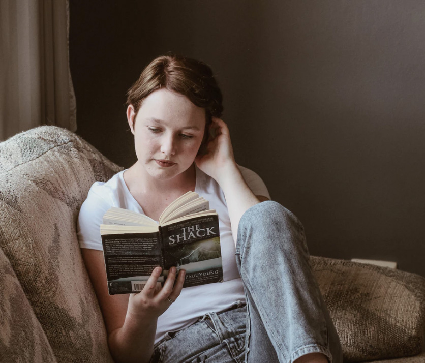 Girl reading a book on the couch