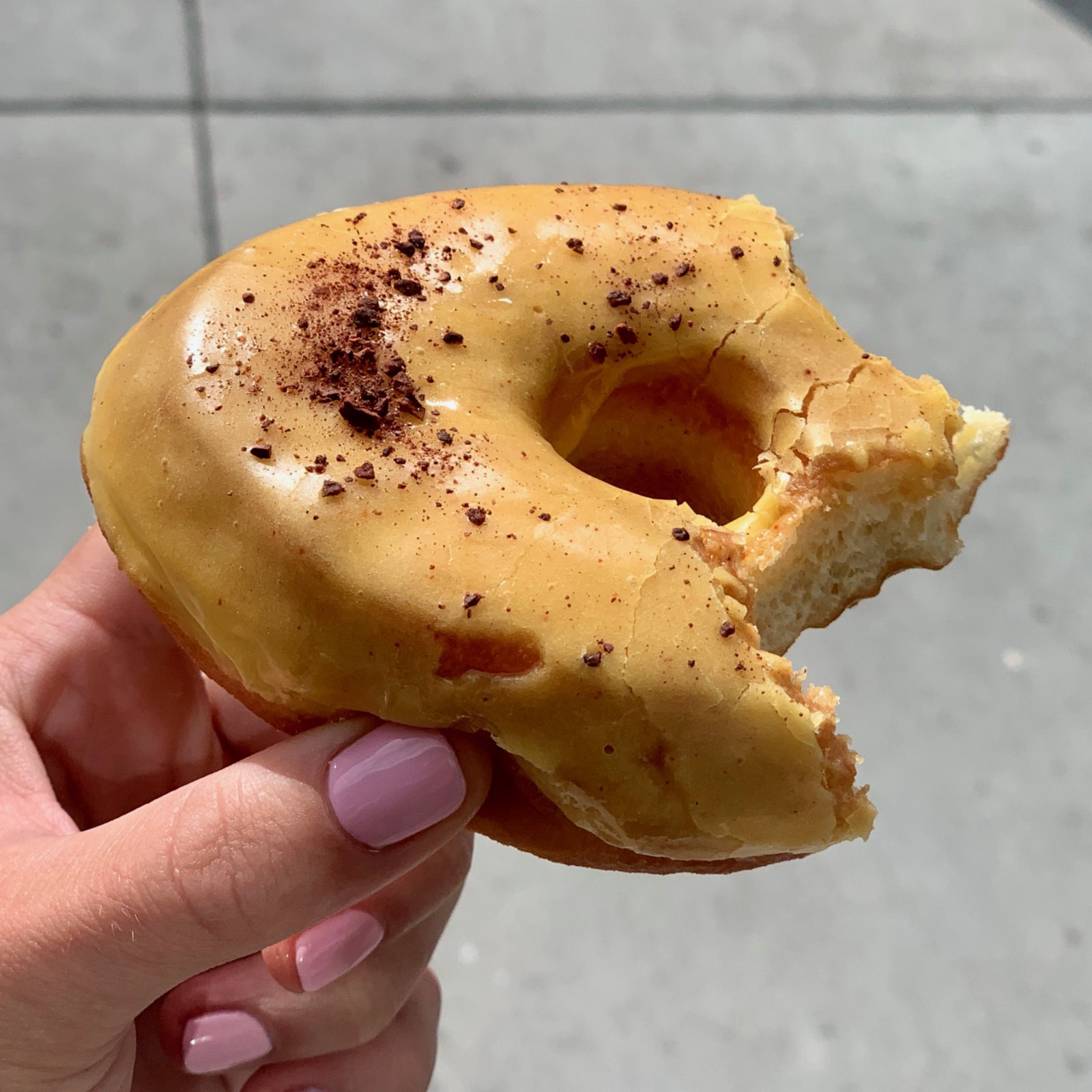 A passion fruit donut with bites out of it from Blue Star Donut in Portland, Oregon