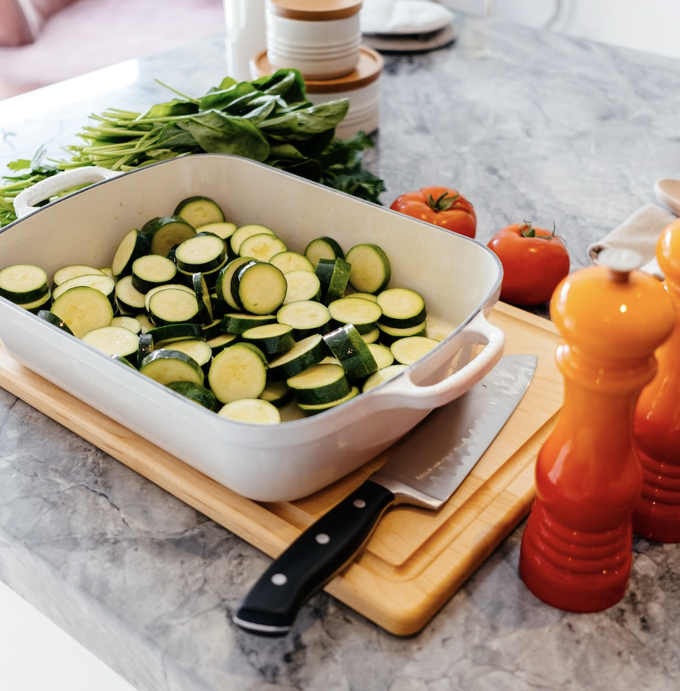 A dinner dish with chopped up zucchini to be prepared for a meal.  