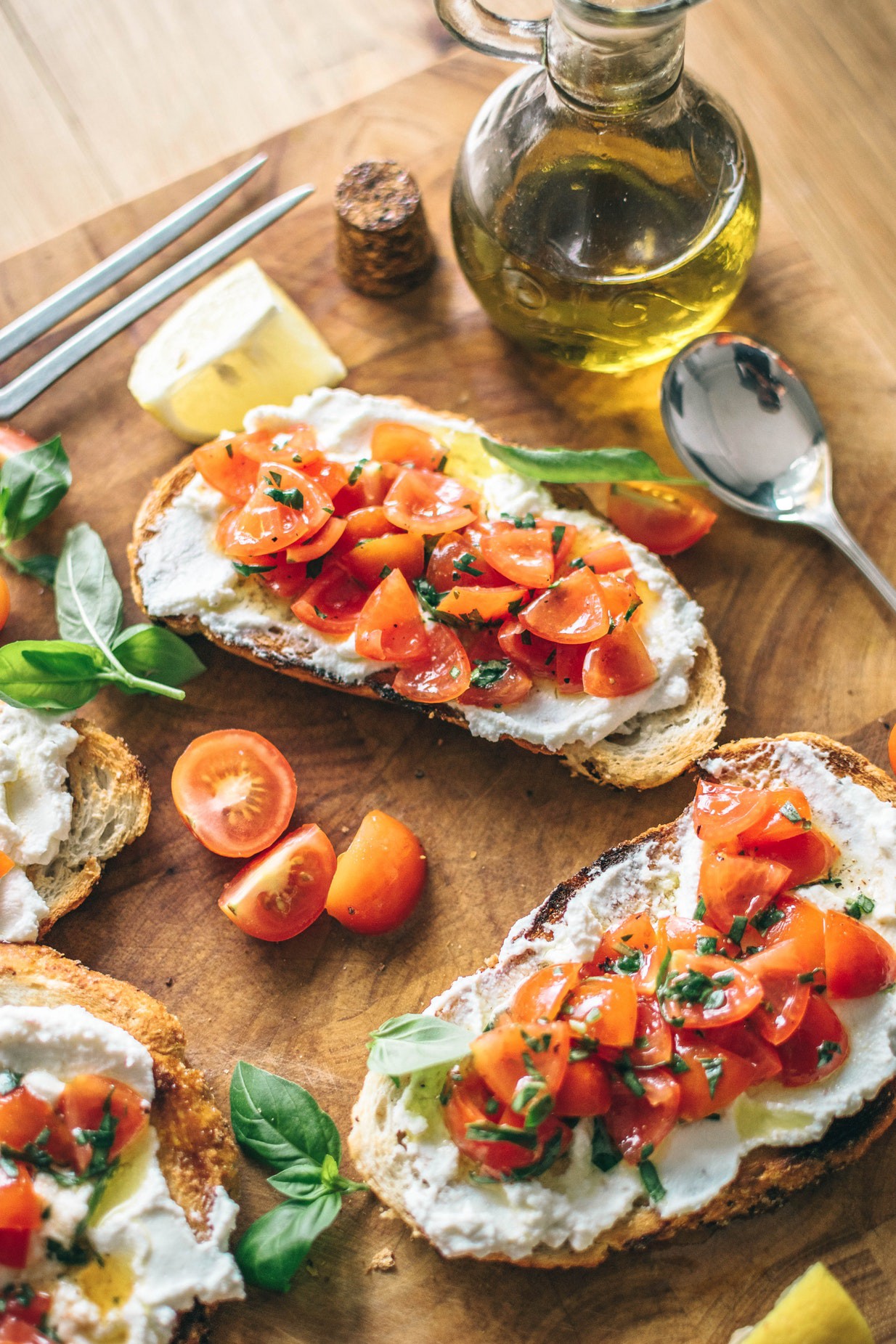 A plate of bread and bruschetta served on a wooden table.