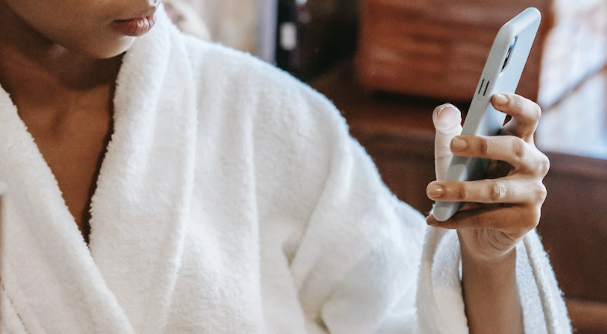 Scrolling phone in morning in bathrobe