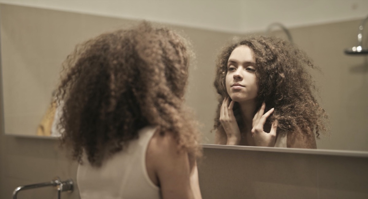 Female looking into the mirror. Image: Pexels - Andrea Piacquadio