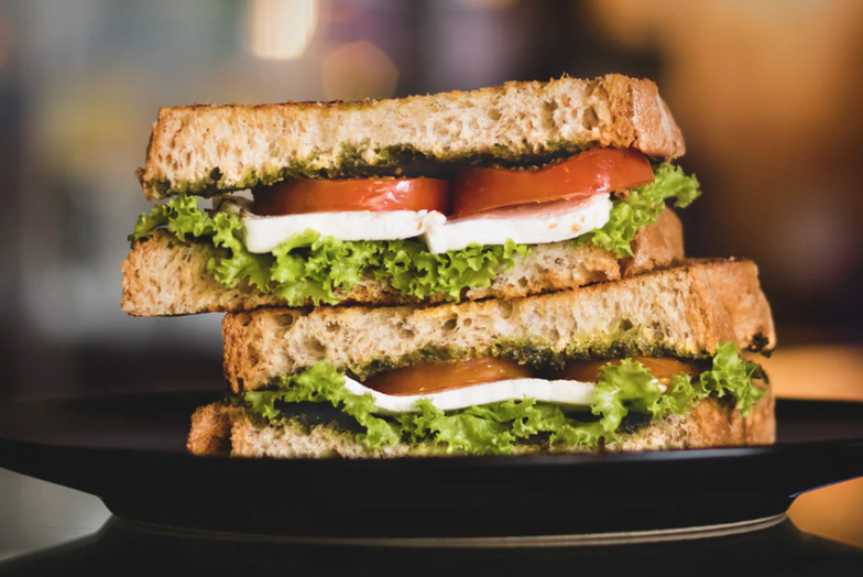 Sandwhich with tomatoes, mozeralla, and lettuce 