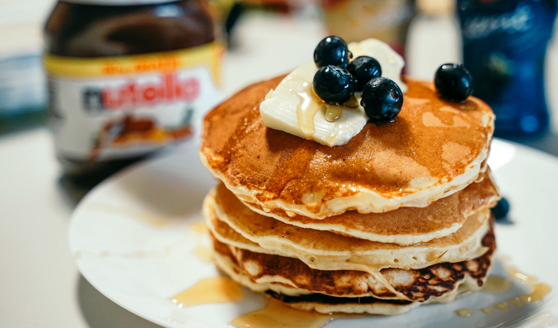 A stack of fresh blueberry pancakes with syrup