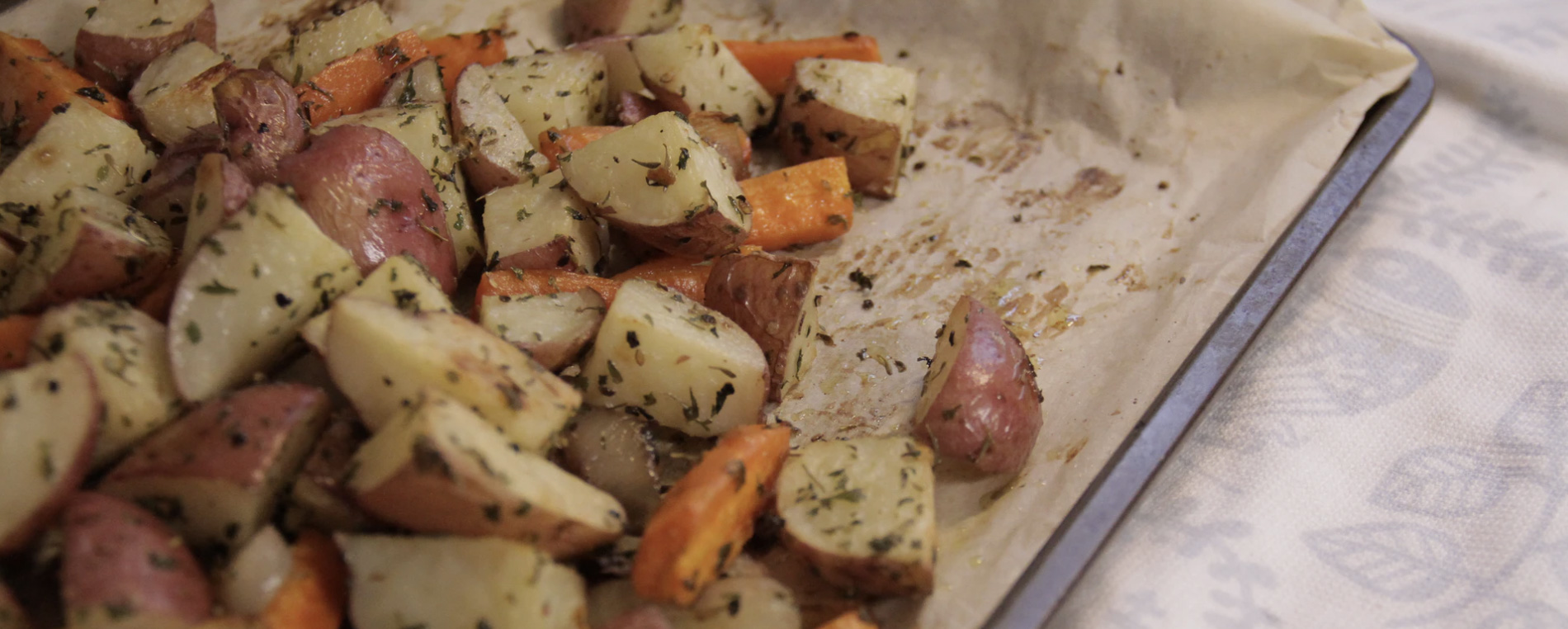 A tray of baked potatoes sliced and seasoned