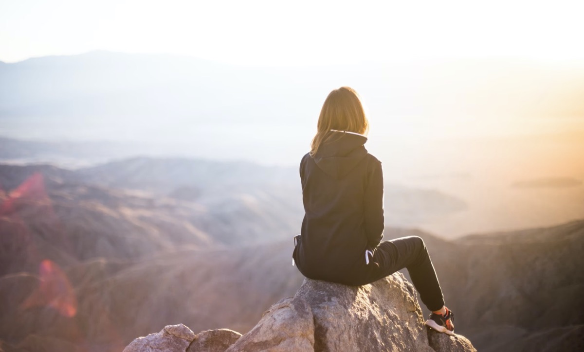 Woman sitting on top of rock in the moutains