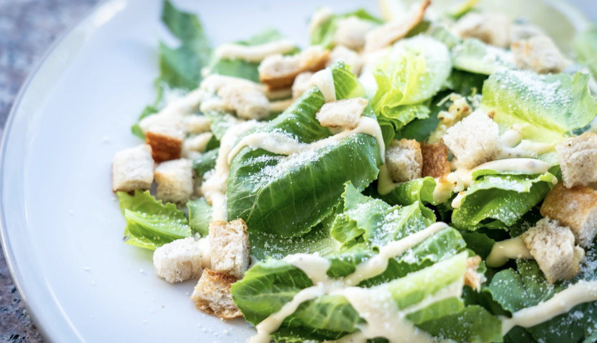 Caesar salad with croutons and dressing.  Unsplash- Chris A. Tweten