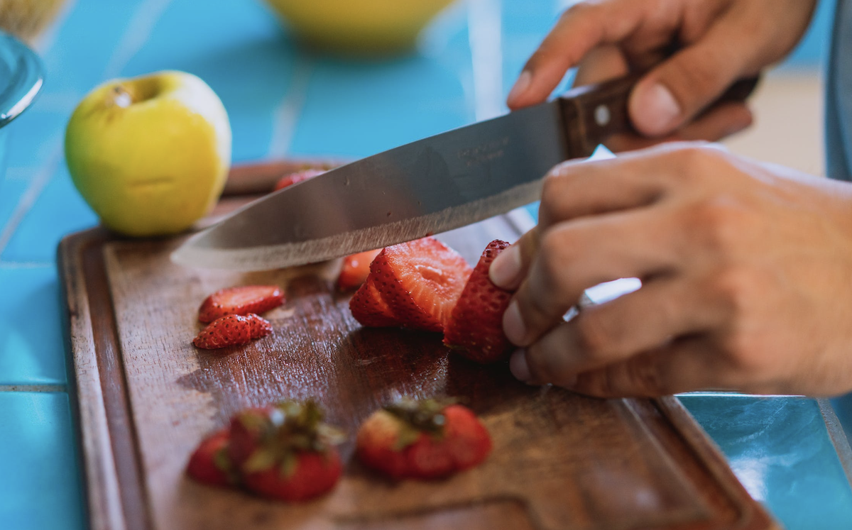 Cutting up strawberries on cutting board