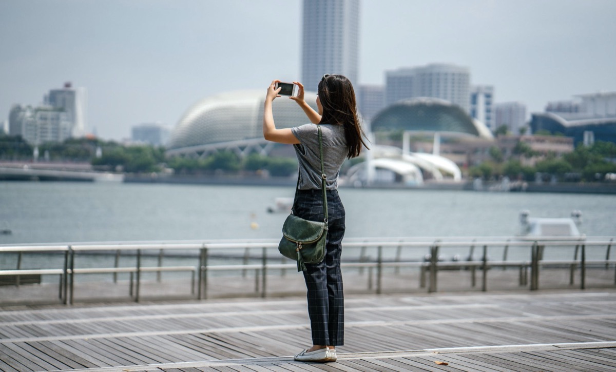 Woman taking picture of a city view.