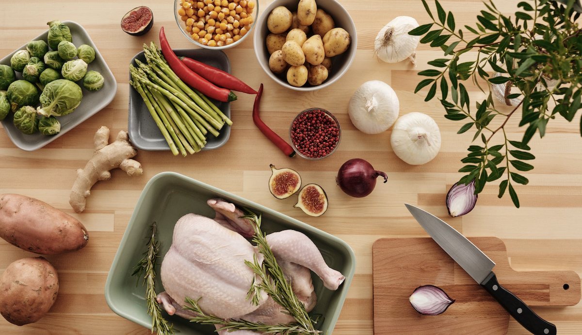 Kitchen table with meat and vegetables. Image: Pexels - Vanessa Loring