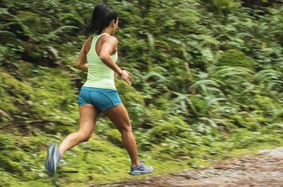 Woman running outside on a trail.